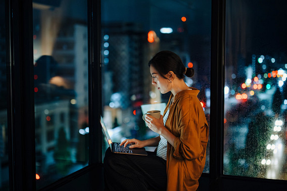 Young woman sat at home while using her laptop