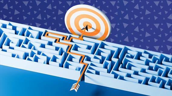 An abstract 3D illustration of a blue maze with a white and orange bullseye target positioned at the top. An orange arrow emerges from the maze, navigating through a complex path towards the target. The background features a purple surface adorned with various geometric shapes, such as triangles. The overall composition symbolizes the concept of overcoming challenges and achieving goals.