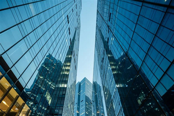 Exterior of modern glass office buildings, with a blue sky above them