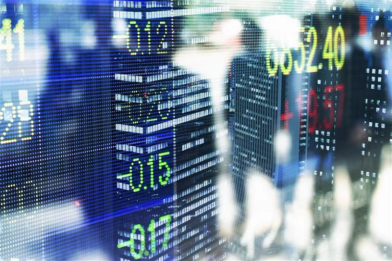 Stock index layers over a dark cityscape at dusk