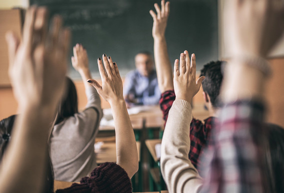Students with hands in air ready to ask speak